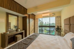 une chambre avec un lit et une grande fenêtre dans l'établissement Idyllic Abode 2 bhk apartment, à Goa
