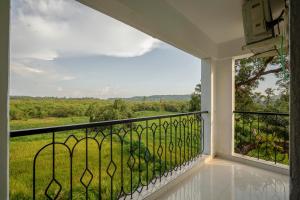 - un balcon avec vue sur un champ dans l'établissement Idyllic Abode 2 bhk apartment, à Goa