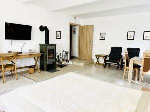 a living room with a television and a table with chairs at Spa Park Guest Rooms in Długopole-Zdrój +127 photos