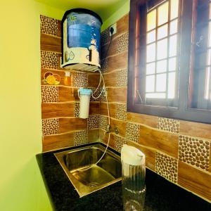 a kitchen counter with a sink and a window at Mayura Homestay in Kanchipuram