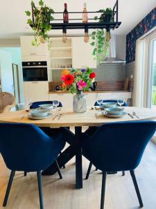 a kitchen with a table with chairs and flowers at Morning Glory Huisje Jasmijn in Beekbergen +14 photos