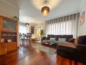 salon z kanapą i stołem w obiekcie Apartamento completo, amplio, muy iluminado y con plaza de garaje incluida. w mieście O Grove