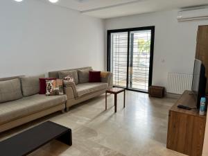 a living room with a couch and a tv at Location appartement luxueux Tunis in Tunis