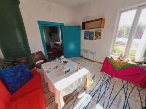 a living room with a white table and a red chair at Eagle's Nest in Karakol +20 photos