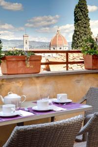 a table with cups and saucers on a balcony at Florence view apartment in Florence