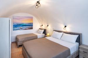 a bedroom with two beds and a painting on the wall at Georgia's Comfort Studio in Perivolos