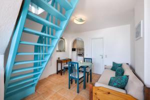 a blue staircase in a living room with a table at Georgia's Comfort Studio in Perivolos +2 photos