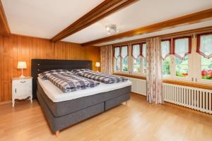 a bedroom with a bed in a room with windows at Cosy Swiss Apartment in Grindelwald