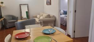 mesa de comedor con copas de vino y sala de estar. en Sabbia Suites El Muellito, en Famara