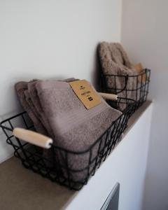 two towels in a basket on a wall at 99 Maison by Noire - Deluxe Bungalow Sibiu in Sibiu