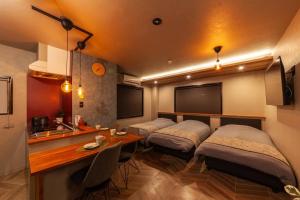 a room with three beds and a kitchen with a table at おやど紀伊国屋玉園町 in Asahimachi