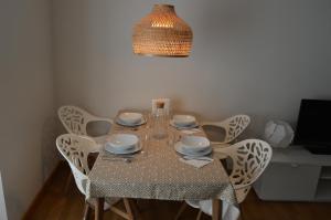 a dining room table with white chairs and a chandelier at Vut Casa de los Leales - Ávila in Ávila