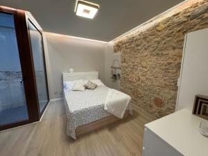 a bedroom with a bed and a stone wall at Casa céntrica en Reus in Reus