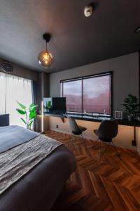 a bedroom with a bed and a desk and two chairs at おやど紀伊国屋玉園町 in Asahimachi