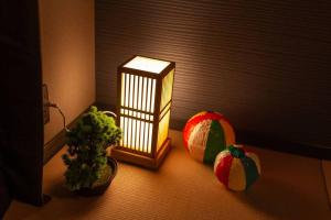 a lamp sitting next to two balls and a plant at おやど紀伊国屋玉園町 in Asahimachi