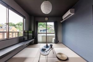 a living room with a table and a large window at おやど紀伊国屋玉園町 in Asahimachi