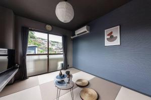 a room with a blue wall with a table and a chair at おやど紀伊国屋玉園町 in Asahimachi