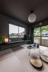 a living room with a table and two windows at おやど紀伊国屋玉園町 in Asahimachi
