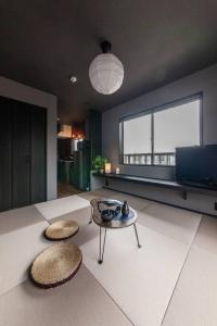 a living room with a table and a large window at おやど紀伊国屋玉園町 in Asahimachi