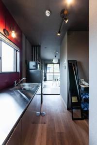 a kitchen with a sink and a refrigerator at おやど紀伊国屋玉園町 in Asahimachi