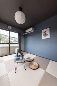 a living room with a table and two stools at おやど紀伊国屋玉園町 in Asahimachi