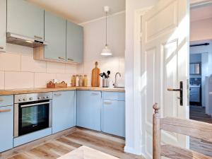 una cucina con mobili blu e un lavandino di Geest Cottage a Großenrade