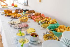 un tavolo bianco con un sacco di cibo sopra di Pousada Linda Vista Socorro SP a Socorro