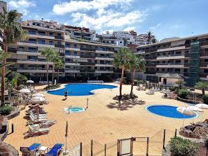 a large swimming pool in front of a large building at Cliffside Residence in Puerto de Santiago