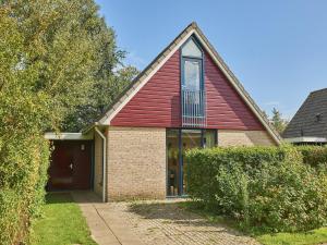 a house with a red roof and a garage at Holiday Home in Zeeland near Beaches in Heinkensand
