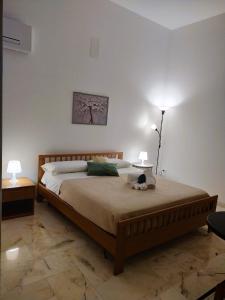 a bedroom with a large bed with two lamps at La Rugiada-con giardino privato in Alcamo
