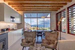 a kitchen with a table and chairs and a large window at Almoxarife Beach House in Praia do Almoxarife