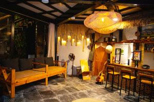 un soggiorno con un divano e un lampadario di The Hideout Villa Pokhara a Pokhara