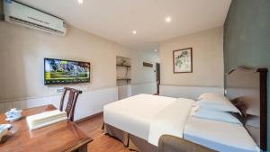 a hotel room with a bed and a desk and a tv at Wenjun Courtyard Hotel ---5 mins walk from Tonghuimen metro station, near Tianfu square, close by culture park and Sichuan opera house, English speaking service, local tours in Chengdu