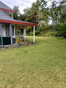 a house with a lawn in front of it at RUs Terraces in Kauri
