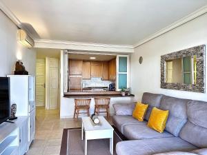 a living room with a couch and a kitchen at Cliffside Residence in Puerto de Santiago