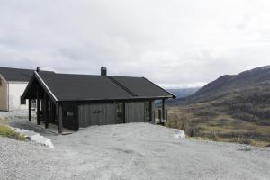 a small building on a hill with mountains in the background at Sogndal Chalet in Sogndal
