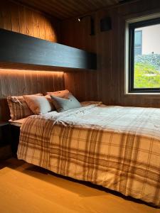 a bedroom with a large bed with a window at Sogndal Chalet in Sogndal