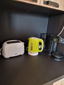a kitchen counter with a toaster and a yellow cup at Le flamantNoir in Créances