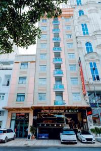 a large building with cars parked in front of it at Linh Phuong 3 Hotel in Can Tho