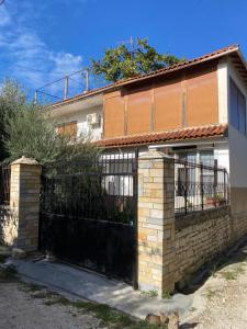 a house with a gate and a fence at Berat Feeling Guesthouse in Berat