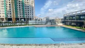 a large swimming pool in a building with tall buildings at Simply Look and Homey Studio Tokyo Riverside PIK 2 Apartment By Travelio in Rawalembang