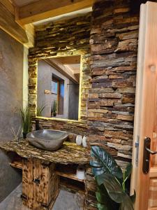a stone bathroom with a sink and a mirror at Leśne Zacisze & Spa na wyłączność in Lubień +135 photos