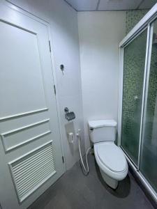 a white bathroom with a toilet and a shower at Cozy 1br walk to BTS and Airport Rail Link Close to Malls 11 in Bangkok