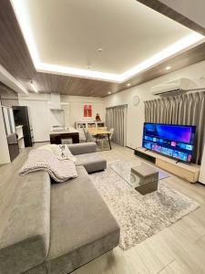 un soggiorno con divano e TV a schermo piatto di MA house 701 ad Osaka