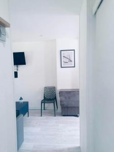 a white room with a chair and a desk at Le Chêne pommier Marine in Fatouville-Grestain