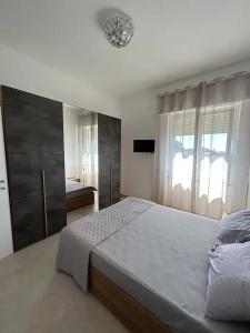 Un dormitorio con una cama grande y una ventana. en Appartamento Martina, en Nettuno