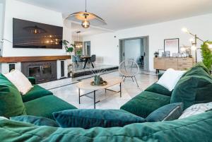 a living room with a green couch and a fireplace at GRR - Elegant Villa with Exclusive Private Pool in Marbella