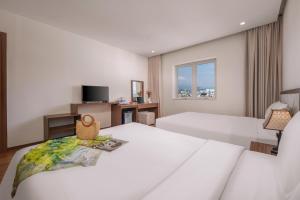 Postel nebo postele na pokoji v ubytování De Lamour Hotel Da Nang