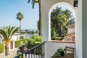 a view from the balcony of a house with palm trees at GRR - Elegant Villa with Exclusive Private Pool in Marbella