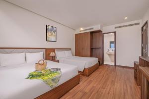 Postel nebo postele na pokoji v ubytování De Lamour Hotel Da Nang